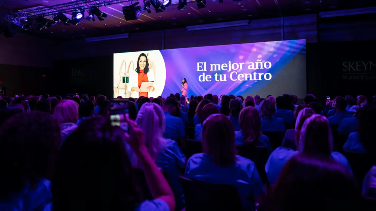Catalina en una conferencia ante un auditorio lleno
